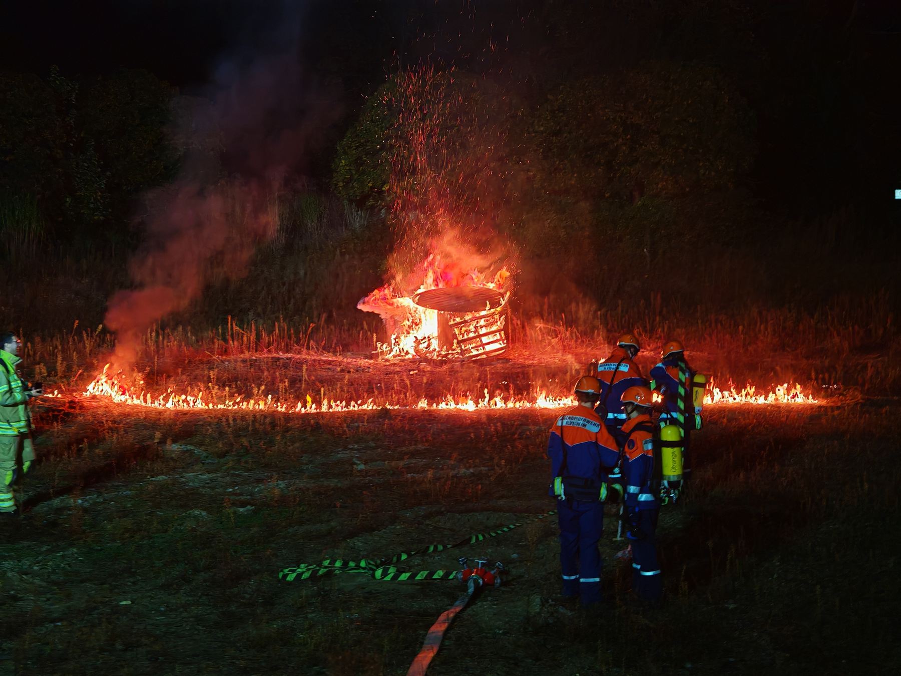 Jugendfeuerwehr Ilvesheim bei einer Nachtübung mit Atemschutz vor brennendem Übungsobjekt