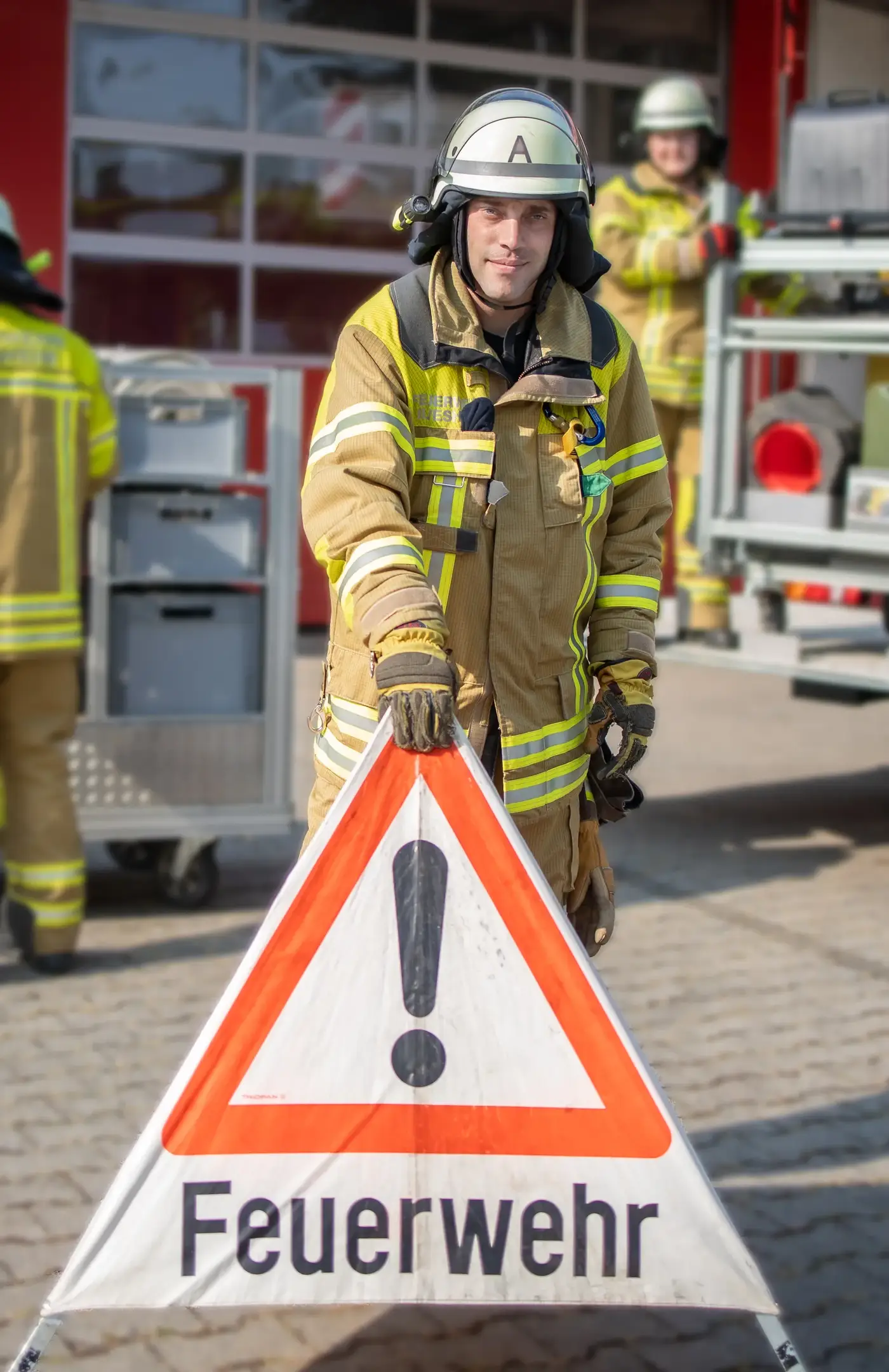 Einsatzkraft mit Warndreieck der Feuerwehr